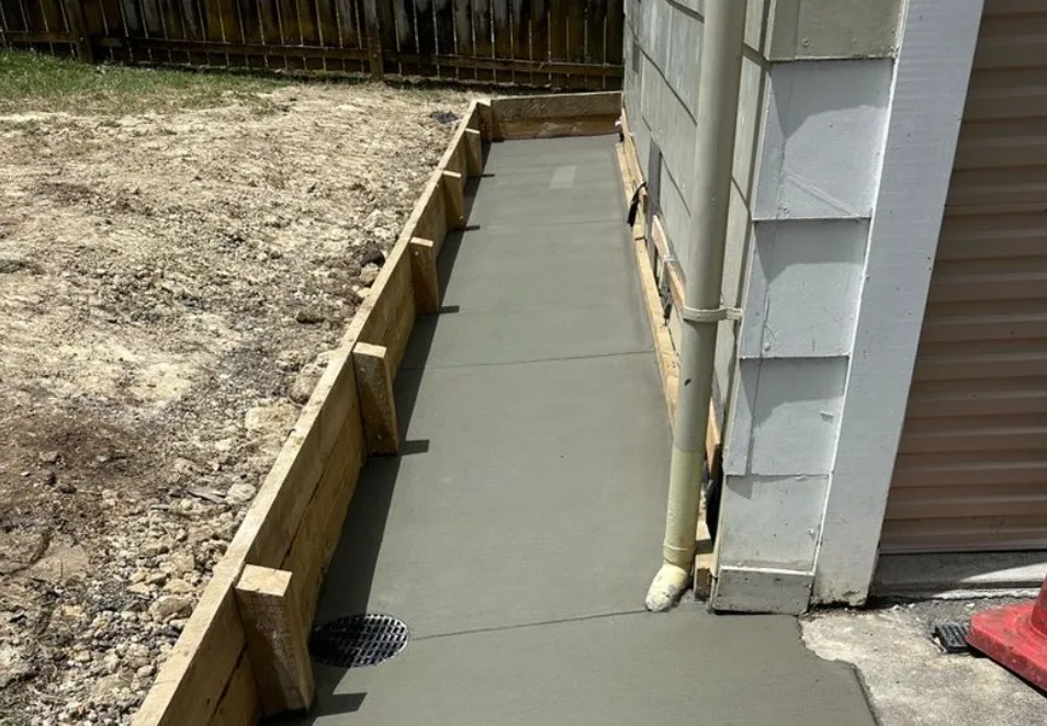 Concrete accessway poured alongside a house with timber boxing still in place