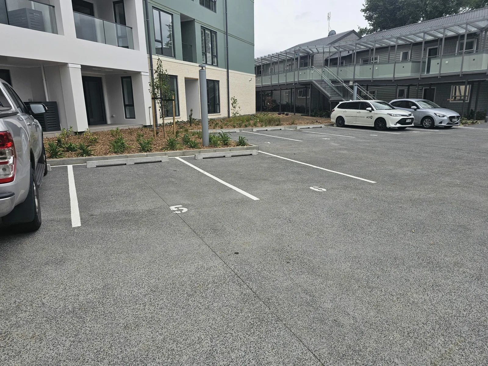 Sealed carpark with fresh line marking beside an apartment building