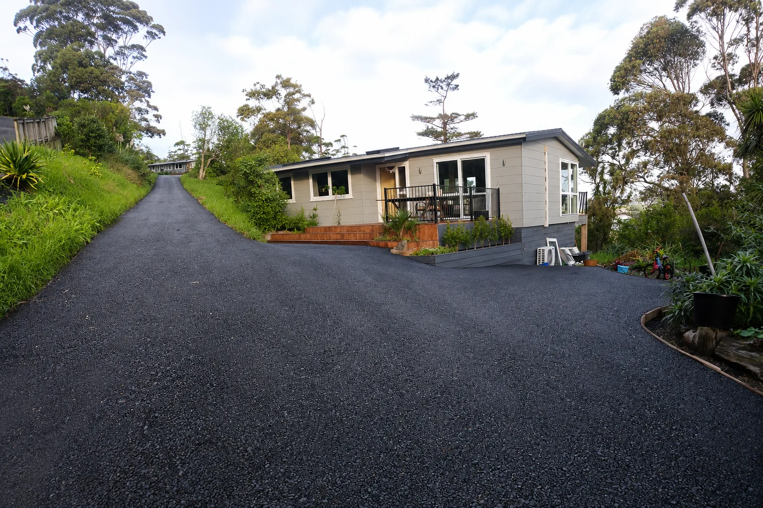 Sealed asphalt driveway leading up to a rural house