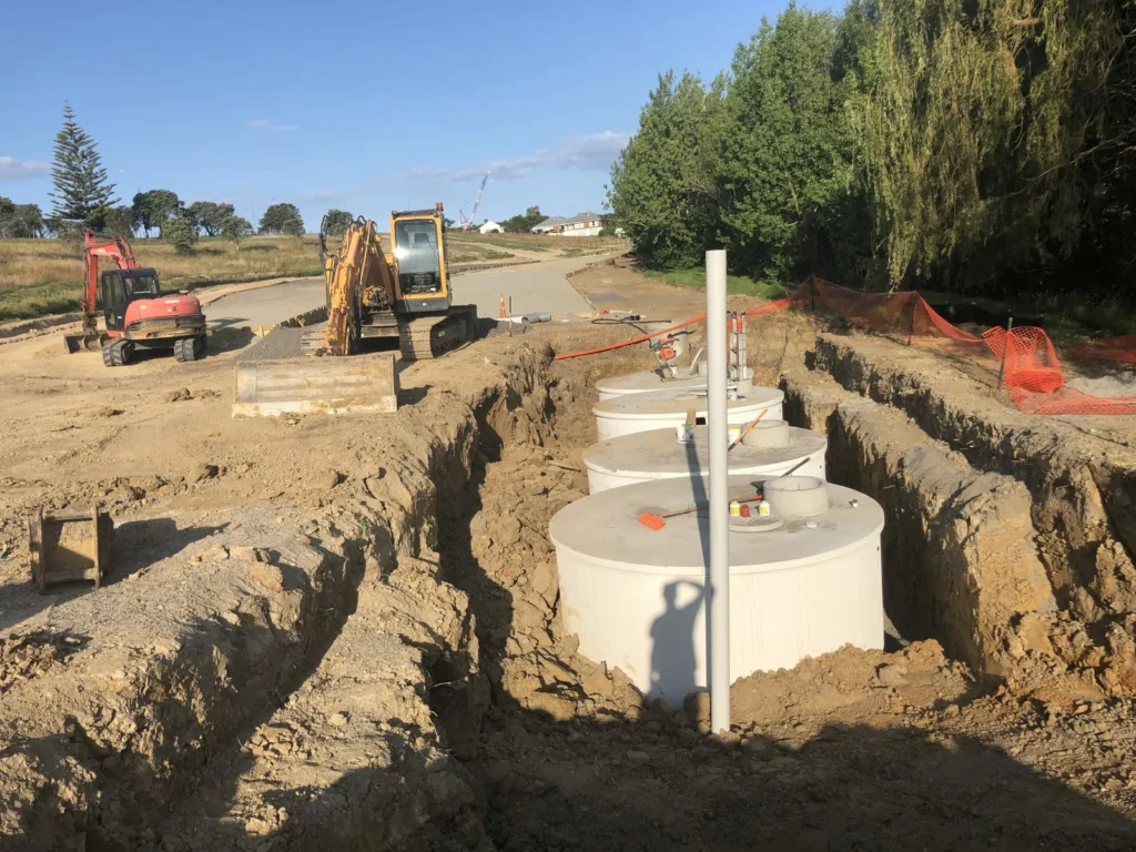 Excavators installing a stormwater chamber in an open trench