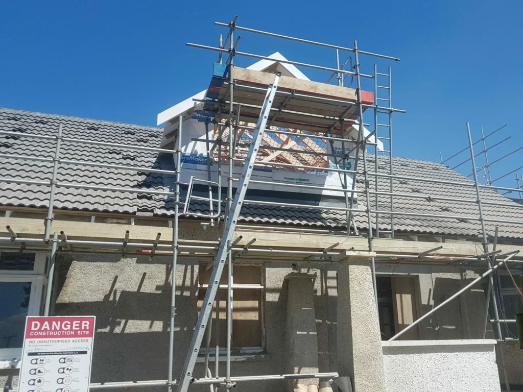 Scaffolding and access ladder against a house under construction